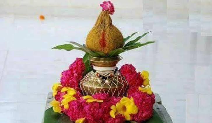 Kalasam decorated with kumkum, coconut and mango leaves
